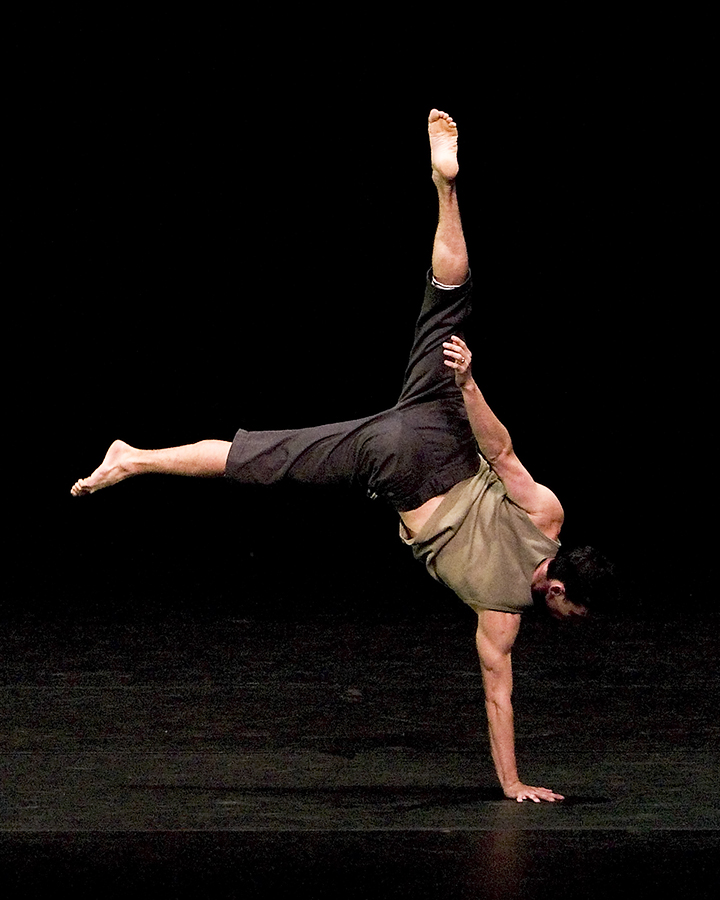A man on stand doing a handstand